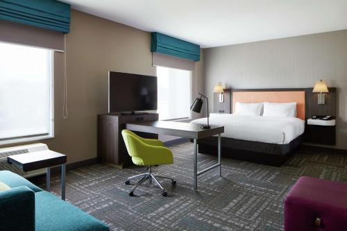 a hotel room with a bed and a desk with a computer at Hampton Inn & Suites Chicago/Waukegan in Waukegan