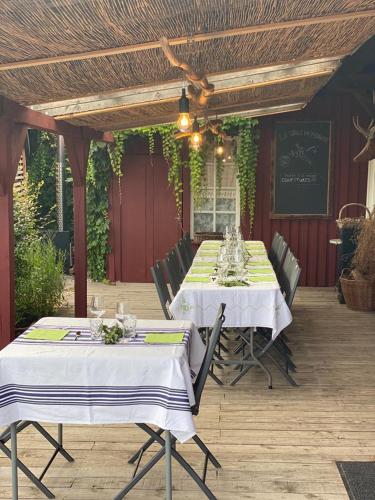 une table avec des nappes blanches sur une terrasse dans l'établissement La Maison du Potager, à Saint-Racho