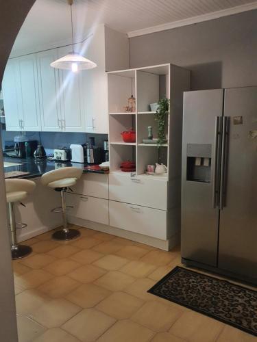 a kitchen with white cabinets and a refrigerator at 67@18th Avenue Beach View, in East London