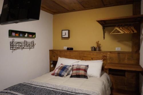 Bett mit einem Kopfteil aus Holz in einem Schlafzimmer in der Unterkunft Lavras Real in Lavras Novas
