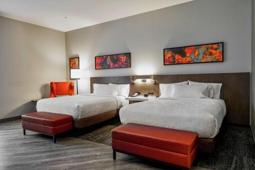 ein Hotelzimmer mit 2 Betten und einem Stuhl in der Unterkunft Hilton Garden Inn Louisville Mall Of St. Matthews in Louisville