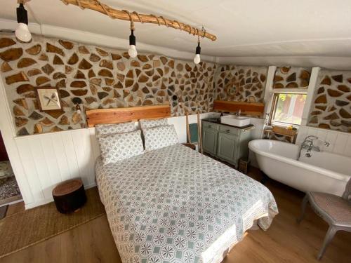 1 dormitorio con cama y bañera en La Maison du Potager, en Saint-Racho