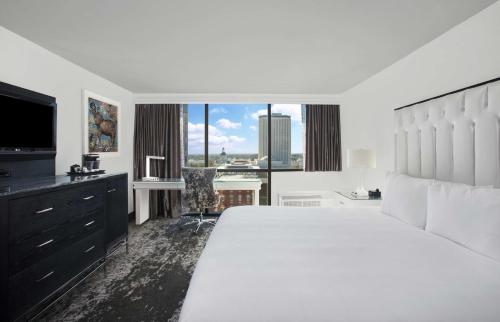 a white bedroom with a large bed and a large window at DoubleTree by Hilton Hotel Tallahassee in Tallahassee