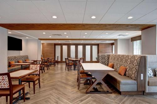 a waiting room with tables and chairs and a couch at Hampton Inn Santa Fe South, NM in Santa Fe