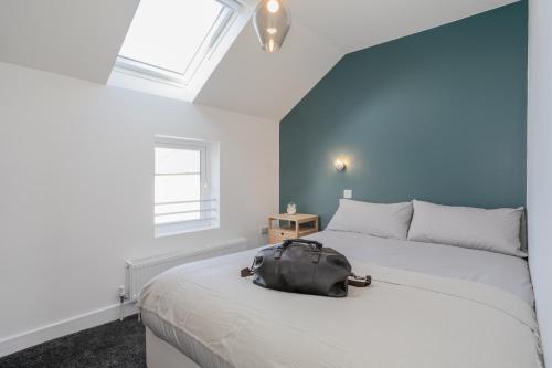 a bag sitting on a bed in a bedroom at Capital East Apartment in Belfast