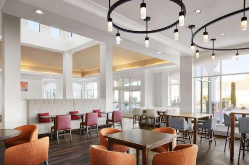 a dining room with tables and chairs and windows at Hilton Garden Inn Las Vegas/Henderson in Las Vegas