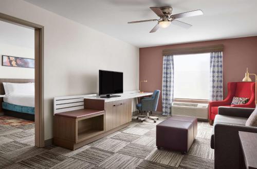 a hotel room with a bed and a desk with a television at Hilton Garden Inn Las Vegas/Henderson in Las Vegas