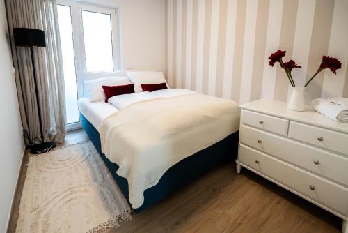 a small bedroom with a bed and a window at Apartments Kras 24 with Pool in Sežana