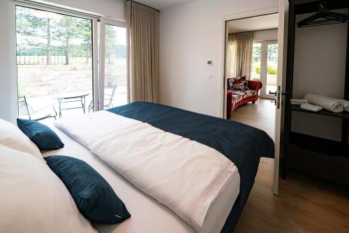 1 dormitorio con 1 cama grande con almohadas azules en Apartments Kras 24 with Pool, en Sežana