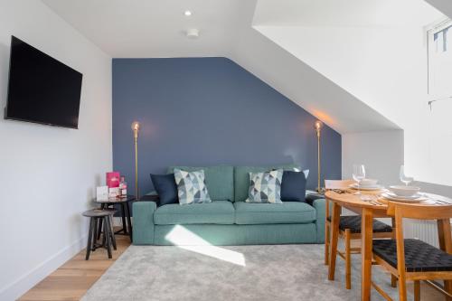 a living room with a blue couch and a table at Capital East Apartment in Belfast