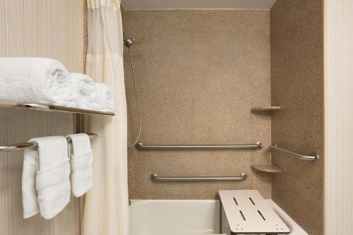 y baño con ducha, aseo y toallas. en Hilton Garden Inn West Monroe, en West Monroe