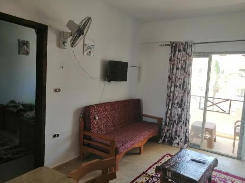 een woonkamer met een bank en een tv bij قرية بلو لا جون شالية رقم 4012 غرفتين بالدور الأول علوي مدينة راس سدر محافظة جنوب سيناء in Ras Sedr