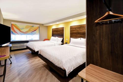 um quarto de hotel com duas camas e uma televisão de ecrã plano em Tru By Hilton Smyrna Nashville em Smyrna