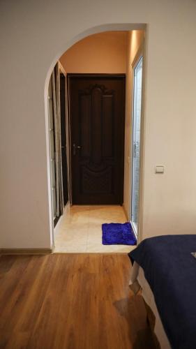 a hallway with a black door and a blue rug at Old Byurakan Gouest House in Byurakan