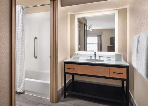 a bathroom with a sink and a tub and a mirror at Homewood Suites by Hilton Baltimore-Washington Intl Apt in Linthicum Heights