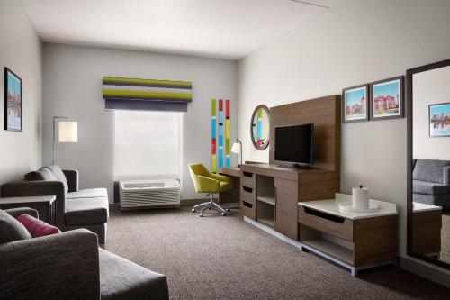 a living room with a couch and a television at Hampton Inn Indianapolis Northwest - Park 100 in Indianapolis
