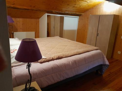 Schlafzimmer mit einem Bett und einer Lampe auf einem Tisch in der Unterkunft Chambre privée dans une maison typique gasconne in Ornézan