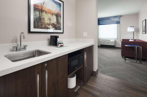 uma cozinha com um lavatório e uma sala de estar em Hampton Inn & Suites Phoenix Downtown em Phoenix