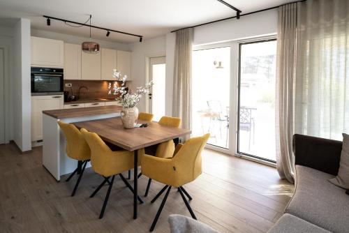 a kitchen and dining room with a wooden table and chairs at Apartments Kras 24 with Pool in Sežana