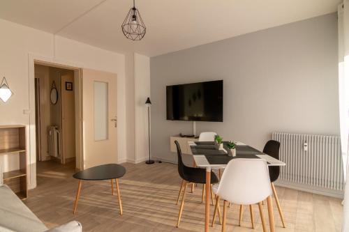 a living room with a dining room table and chairs at LeSaumurTranquille - Les VioIettes in Saumur