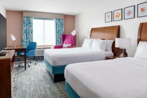 a hotel room with two beds and a desk at Hilton Garden Inn Orlando at SeaWorld in Orlando