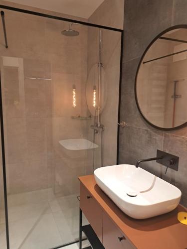 a bathroom with a shower and a sink and a mirror at Golden Apartments Świętej Barbary in Gdańsk