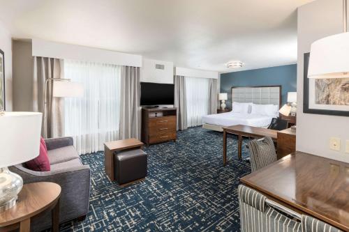 マウント・ローレルにあるHomewood Suites by Hilton Mount Laurelのキングベッド1台とリビングルームが備わる客室です。