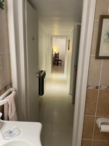 ein Badezimmer mit einem weißen Waschbecken und einem Flur in der Unterkunft Departamento a metros de Peatonal in Mendoza