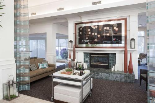 a living room with a fireplace and a tv at Hilton Garden Inn Savannah Airport in Savannah