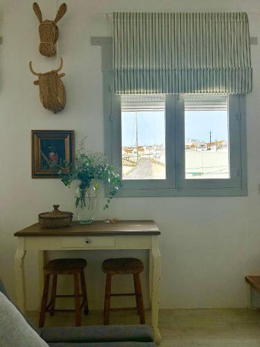 a room with a table and two stools and a window at Almaraz11 in Vejer de la Frontera
