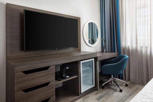 a hotel room with a television and a chair at Hampton Inn & Suites Baltimore Inner Harbor in Baltimore