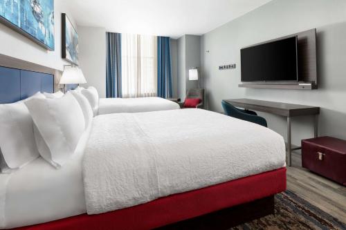 a hotel room with two beds and a flat screen tv at Hampton Inn & Suites Baltimore Inner Harbor in Baltimore