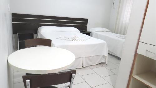 a room with two beds and a table and chairs at Laf Hotel in Registro