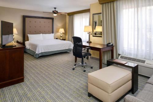 a hotel room with a bed and a desk at Homewood Suites by Hilton Fresno in Fresno