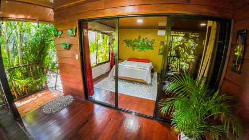 a bedroom with a bed in a room with trees at Bungalows Las Iguanas Arenal Volcano in Chachagua