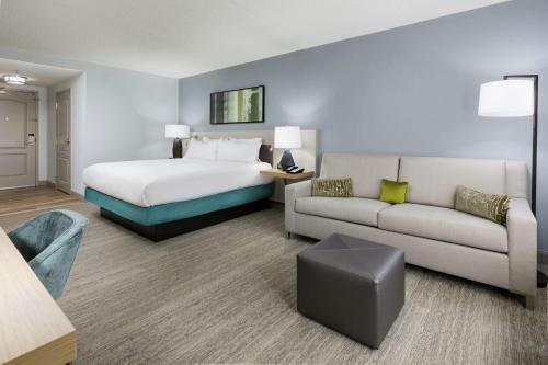 une chambre d'hôtel avec un lit et un canapé dans l'établissement Hilton Garden Inn Greenville, à Greenville
