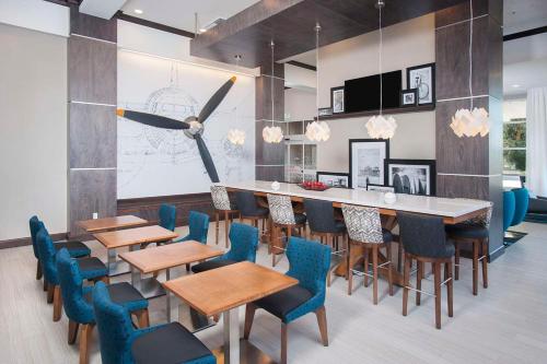 a dining room with tables and chairs and a bar at Hampton Inn & Suites LAX El Segundo in El Segundo