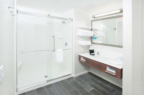 a bathroom with a shower and a sink and a mirror at Hampton Inn & Suites LAX El Segundo in El Segundo