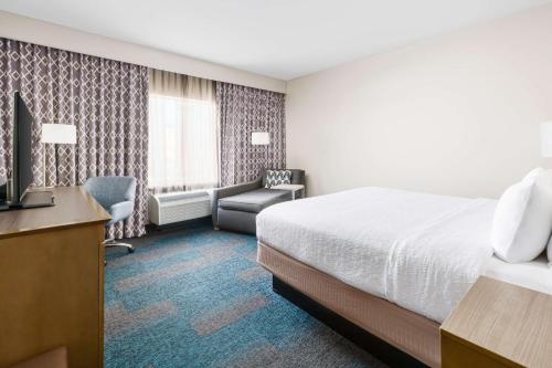 a hotel room with a bed and a desk and chair at Hampton Inn & Suites LAX El Segundo in El Segundo