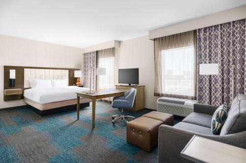 エル・セグンドにあるハンプトン イン ＆ スイーツ LAX エル セグンドのベッドとデスクが備わるホテルルームです。