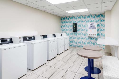 a laundry room with white washing machines and a stool at Homewood Suites by Hilton Myrtle Beach Oceanfront in Myrtle Beach