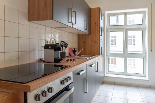 a kitchen with a stove top oven next to a window at Studio THREE / Wifi / Netflix / 3 getrennte Betten in Chemnitz