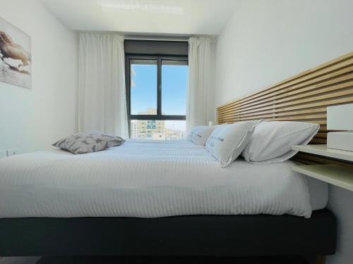 a bedroom with a large bed with a window at Savion View Apartment - Jerusalem City Center in Jerusalem