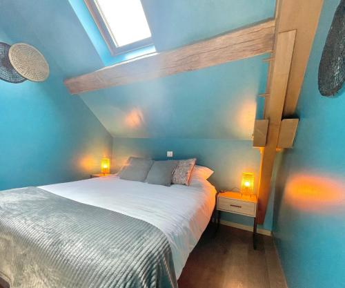 een slaapkamer met een bed met blauwe muren en 2 lampen bij Gîte de la petite charriere in Santenay