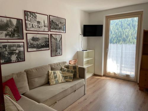sala de estar con sofá y ventana en Appartamento in villetta sulle dolomiti di Brenta, en Pracorno di Rabbi