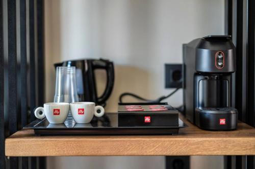 eine Kaffeemaschine und zwei Kaffeetassen auf dem Tisch in der Unterkunft LANGO LUXURY LIVING s in Syvota