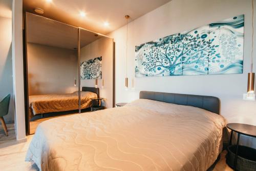 um quarto com uma cama e um quadro na parede em Appartamento Meda - Lakeside Leisure & Business em Cissano