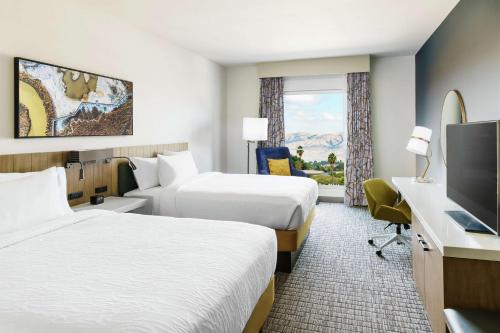 a hotel room with two beds and a flat screen tv at Hilton Garden Inn Sunnyvale in Sunnyvale