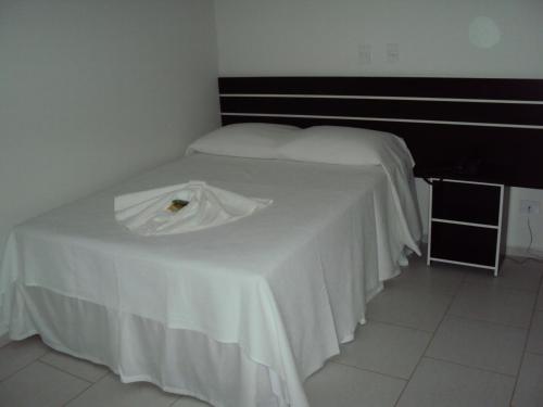 a bed with a white table in a room at Laf Hotel in Registro