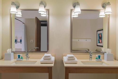 La salle de bains est pourvue de 2 lavabos et d'un grand miroir. dans l'établissement Four Points by Sheraton Midland, à Midland
